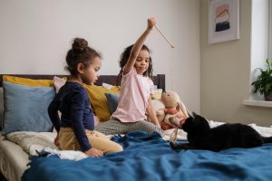 kids with cat on bed